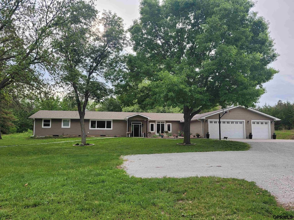 8001 SW 24th St, Lincoln, NE 68523 - ranch-style house featuring gravel driveway, a front yard, and an attached garage