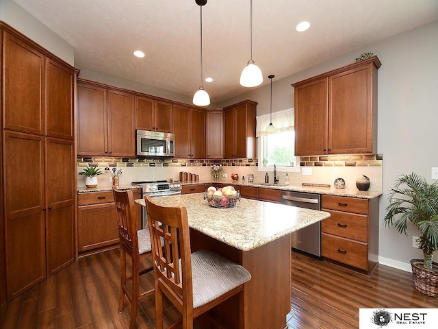 7521 Exbury Rd, Lincoln, NE 68516 - kitchen featuring stainless steel appliances, a sink, dark wood finished floors, backsplash, and recessed lighting