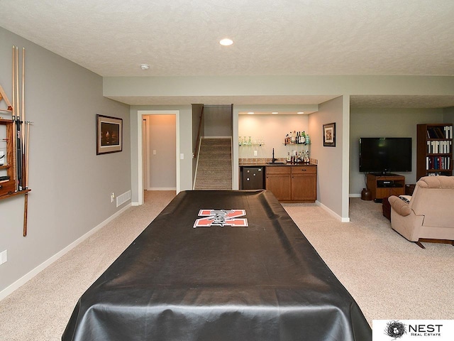 7521 Exbury Rd, Lincoln, NE 68516 - recreation room with light carpet, bar, baseboards, a textured ceiling, and recessed lighting