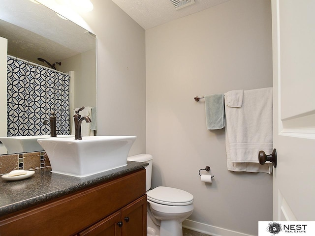 7521 Exbury Rd, Lincoln, NE 68516 - bathroom with vanity, toilet, and a textured ceiling