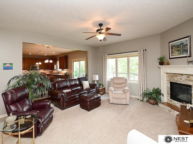 7521 Exbury Rd, Lincoln, NE 68516 - living room with ceiling fan, light carpet, healthy amount of natural light, and a stone fireplace
