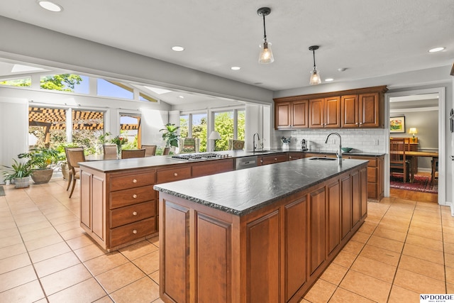 9826 Harney Pkwy N, Omaha, NE 68114 - kitchen with a center island with sink, a sink, stainless steel appliances, light tile patterned flooring, and lofted ceiling