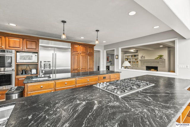 9826 Harney Pkwy N, Omaha, NE 68114 - kitchen with built in appliances, a sink, recessed lighting, brown cabinets, and hanging light fixtures