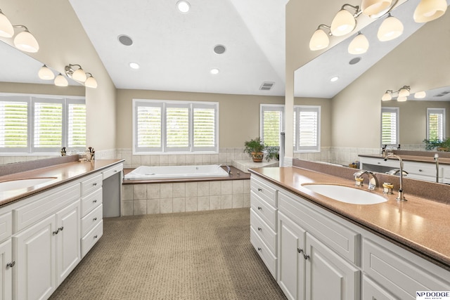 9826 Harney Pkwy N, Omaha, NE 68114 - full bathroom with vaulted ceiling, two vanities, a bath, and recessed lighting