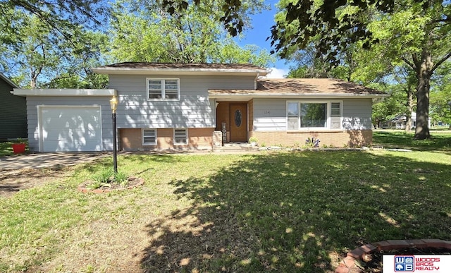 1241 Bessie St, Goehner, NE 68364 - split level home featuring an attached garage, a front lawn, brick siding, and driveway