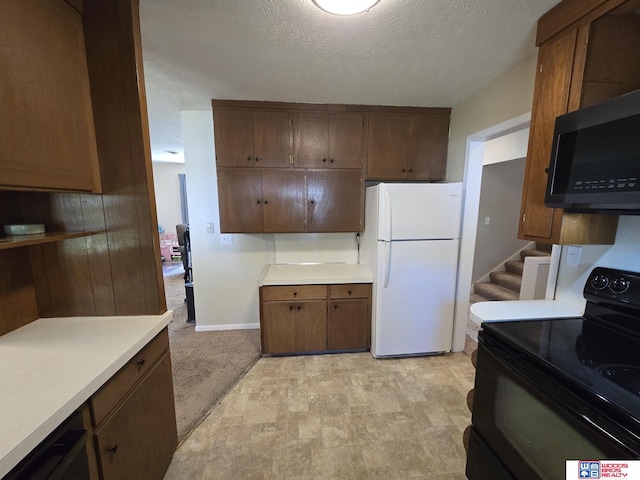 1241 Bessie St, Goehner, NE 68364 - kitchen featuring black / electric stove, freestanding refrigerator, a textured ceiling, light countertops, and baseboards
