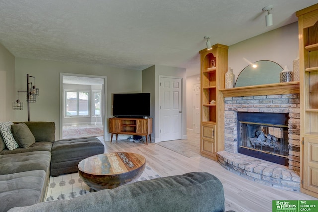1014 Hickory Hill Rd, Papillion, NE 68046 - living room with wood finished floors, a fireplace, and a textured ceiling