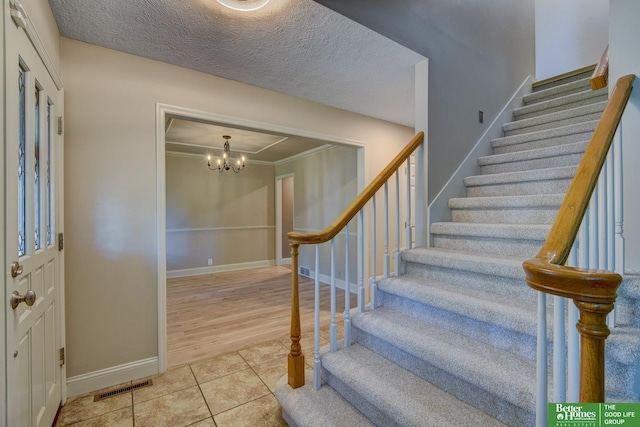 1014 Hickory Hill Rd, Papillion, NE 68046 - entrance foyer featuring stairway, tile patterned floors, a chandelier, baseboards, and ornamental molding