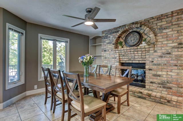 1014 Hickory Hill Rd, Papillion, NE 68046 - dining area featuring light tile patterned floors, a fireplace, baseboards, a ceiling fan, and a textured ceiling
