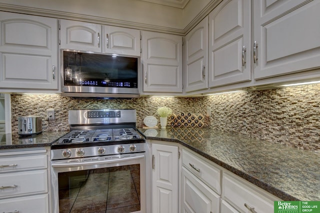 1014 Hickory Hill Rd, Papillion, NE 68046 - kitchen featuring stainless steel appliances, decorative backsplash, dark stone countertops, and white cabinetry