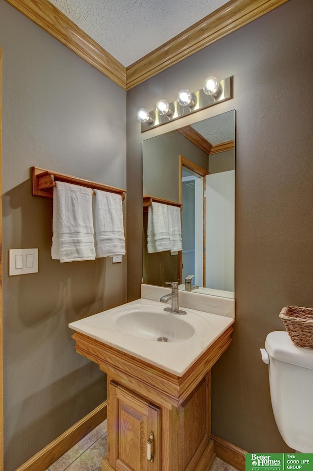 1014 Hickory Hill Rd, Papillion, NE 68046 - bathroom with ornamental molding, baseboards, toilet, vanity, and a textured ceiling