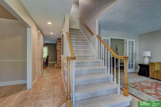 1014 Hickory Hill Rd, Papillion, NE 68046 - staircase with a textured ceiling, baseboards, recessed lighting, and french doors
