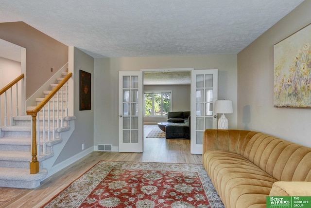 1014 Hickory Hill Rd, Papillion, NE 68046 - living room with french doors, wood finished floors, a textured ceiling, stairs, and baseboards