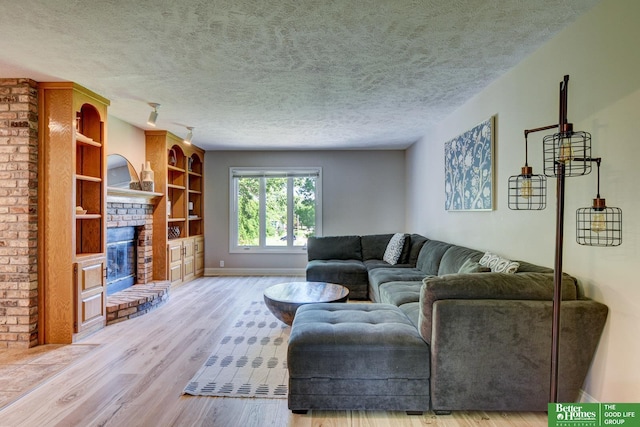 1014 Hickory Hill Rd, Papillion, NE 68046 - living room featuring a textured ceiling, wood finished floors, a fireplace, baseboards, and built in features