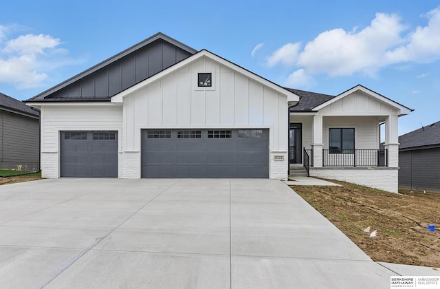 8218 N 167th Ave, Bennington, NE 68007 - modern farmhouse style home featuring an attached garage, concrete driveway, board and batten siding, and a porch