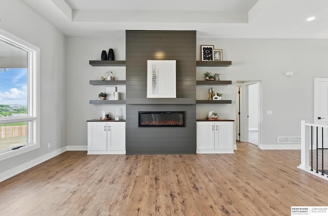8218 N 167th Ave, Bennington, NE 68007 - unfurnished living room with light wood finished floors, a fireplace, baseboards, and a tray ceiling
