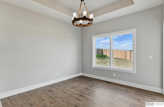 8218 N 167th Ave, Bennington, NE 68007 - empty room featuring a chandelier, baseboards, and wood finished floors