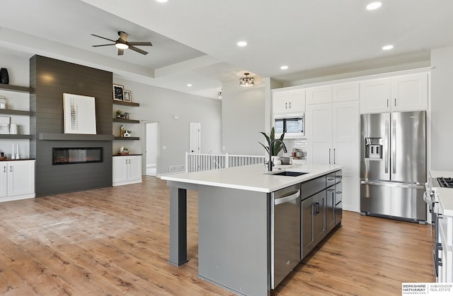 8218 N 167th Ave, Bennington, NE 68007 - kitchen with stainless steel appliances, a sink, open floor plan, white cabinetry, and a large fireplace