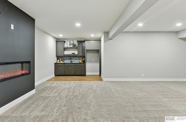 8218 N 167th Ave, Bennington, NE 68007 - bar area featuring light colored carpet, a sink, recessed lighting, a glass covered fireplace, and baseboards