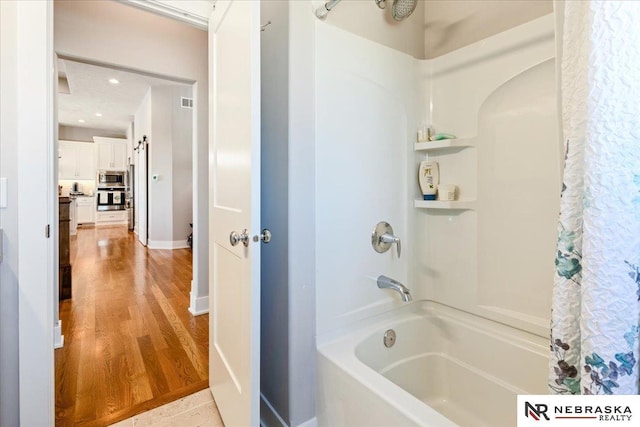 12601 S 78th St, Papillion, NE 68046 - full bathroom with shower / bath combo with shower curtain and wood finished floors
