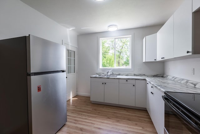 425 W Eagle St, Arlington, NE 68002 - kitchen featuring freestanding refrigerator, a sink, light wood-type flooring, white cabinetry, and light stone countertops