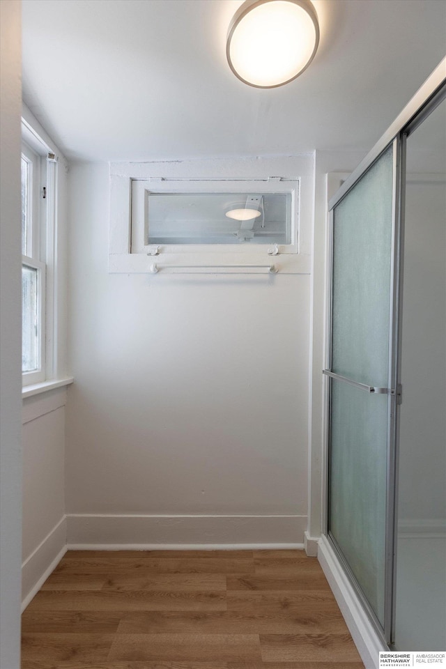 425 W Eagle St, Arlington, NE 68002 - full bathroom with wood finished floors, a shower with shower door, and baseboards