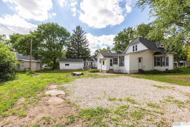 425 W Eagle St, Arlington, NE 68002 - back of property featuring a lawn, gravel driveway, an outbuilding, and entry steps