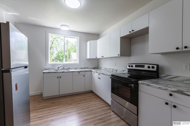 425 W Eagle St, Arlington, NE 68002 - kitchen featuring appliances with stainless steel finishes, a sink, light wood finished floors, and white cabinets