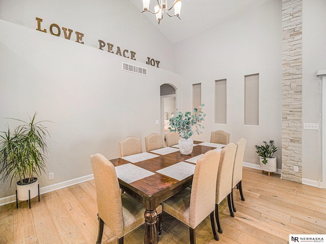 9656 White Pine Rd, Lincoln, NE 68505 - dining area with high vaulted ceiling, light wood-type flooring, baseboards, a chandelier, and arched walkways