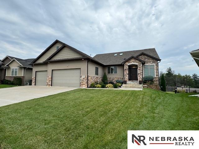 9656 White Pine Rd, Lincoln, NE 68505 - view of front of home with a garage, concrete driveway, a front yard, and stone siding