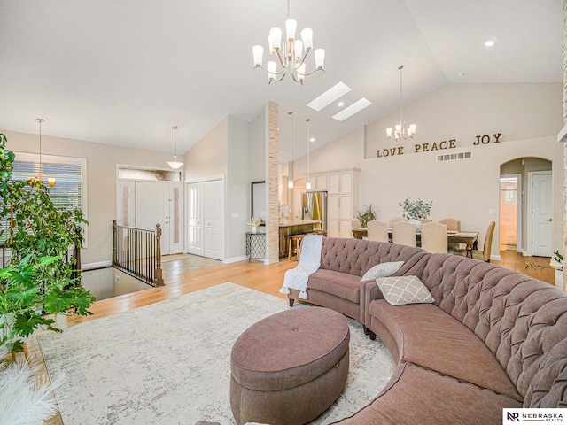 9656 White Pine Rd, Lincoln, NE 68505 - living room featuring a chandelier, light wood-type flooring, high vaulted ceiling, and arched walkways