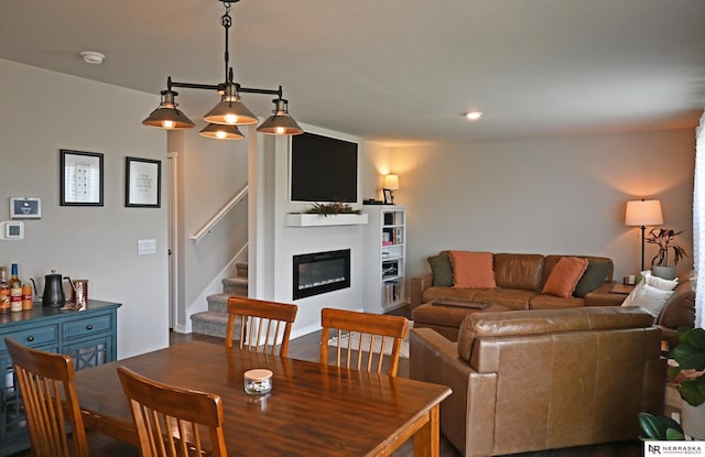 4401 Leawood Dr, Bellevue, NE 68123 - dining space featuring a glass covered fireplace and stairway