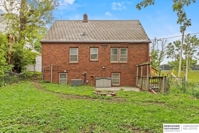 5101 Maple St, Omaha, NE 68104 - back of house with central air condition unit, a chimney, brick siding, and a shingled roof