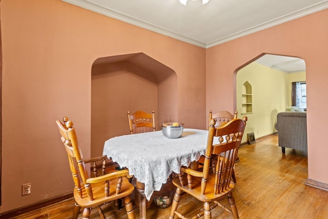 5101 Maple St, Omaha, NE 68104 - dining space featuring arched walkways, ornamental molding, wood finished floors, and baseboards