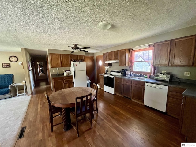 606 E 7th St, Valentine, NE 69201 - kitchen with white appliances, under cabinet range hood, dark wood-type flooring, a sink, and a textured ceiling