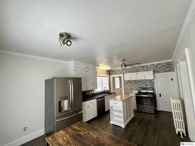 238 N Ray St, Valentine, NE 69201 - kitchen featuring stainless steel appliances, ornamental molding, white cabinetry, dark wood finished floors, and ceiling fan