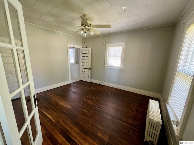 238 N Ray St, Valentine, NE 69201 - spare room with dark wood-type flooring, radiator heating unit, a ceiling fan, baseboards, and a pendent fire sprinkler