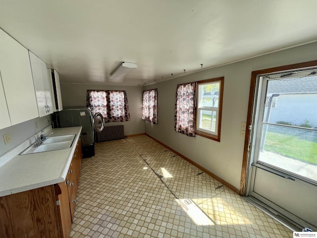 238 N Ray St, Valentine, NE 69201 - kitchen featuring a sink, radiator, light countertops, white cabinetry, and baseboards