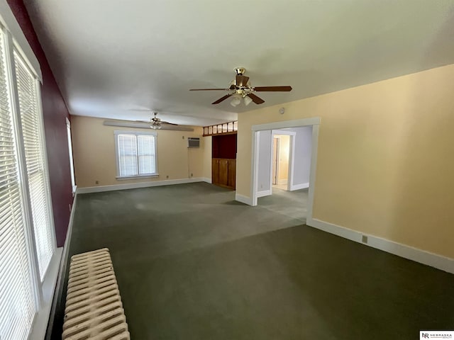 238 N Ray St, Valentine, NE 69201 - unfurnished living room with a ceiling fan, baseboards, dark colored carpet, and an AC wall unit