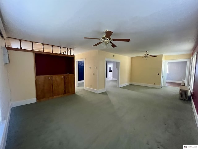 238 N Ray St, Valentine, NE 69201 - unfurnished living room with carpet, ceiling fan, baseboards, and radiator heating unit