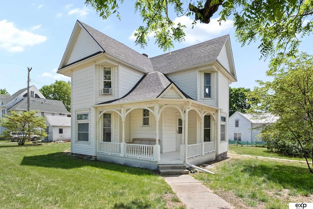 1346 G St, Pawnee City, NE 68420 - victorian home with a porch, a front lawn, and roof with shingles