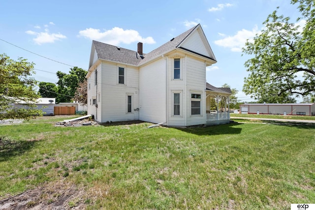 1346 G St, Pawnee City, NE 68420 - rear view of property featuring a chimney, a yard, and roof with shingles