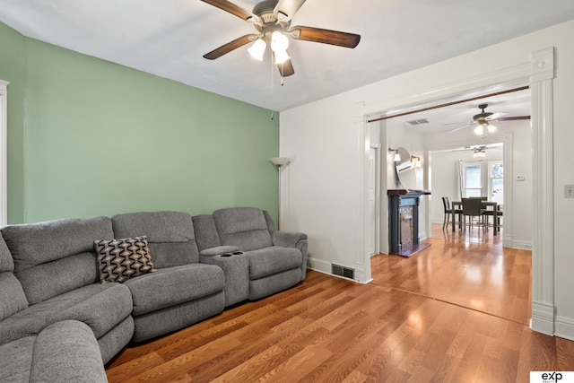 1346 G St, Pawnee City, NE 68420 - living room with a ceiling fan, light wood-type flooring, a fireplace, and baseboards