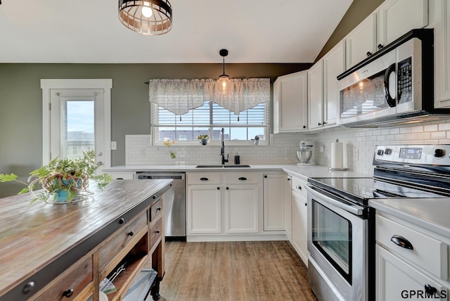 4441 W Hub Hall Dr, Lincoln, NE 68528 - kitchen featuring stainless steel appliances, a sink, tasteful backsplash, lofted ceiling, and white cabinetry