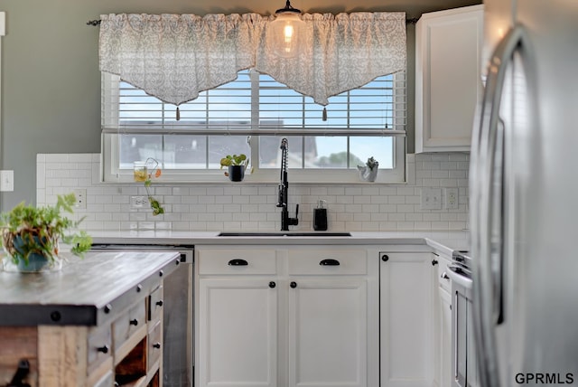 4441 W Hub Hall Dr, Lincoln, NE 68528 - kitchen featuring stainless steel fridge, a sink, tasteful backsplash, and white cabinets