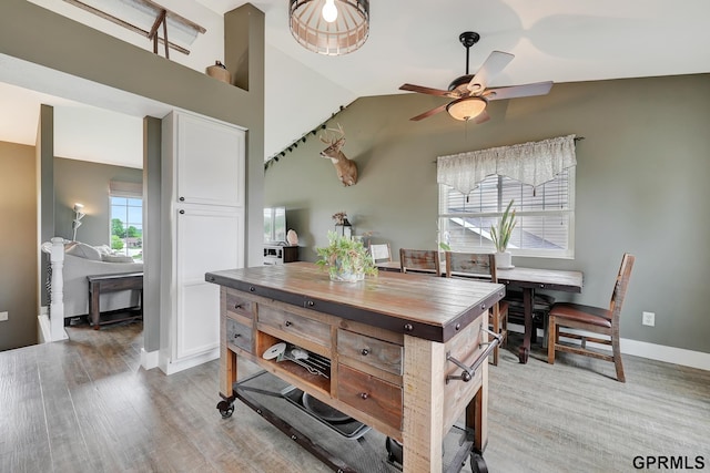 4441 W Hub Hall Dr, Lincoln, NE 68528 - kitchen with butcher block countertops, white cabinets, a ceiling fan, vaulted ceiling, and light wood-type flooring