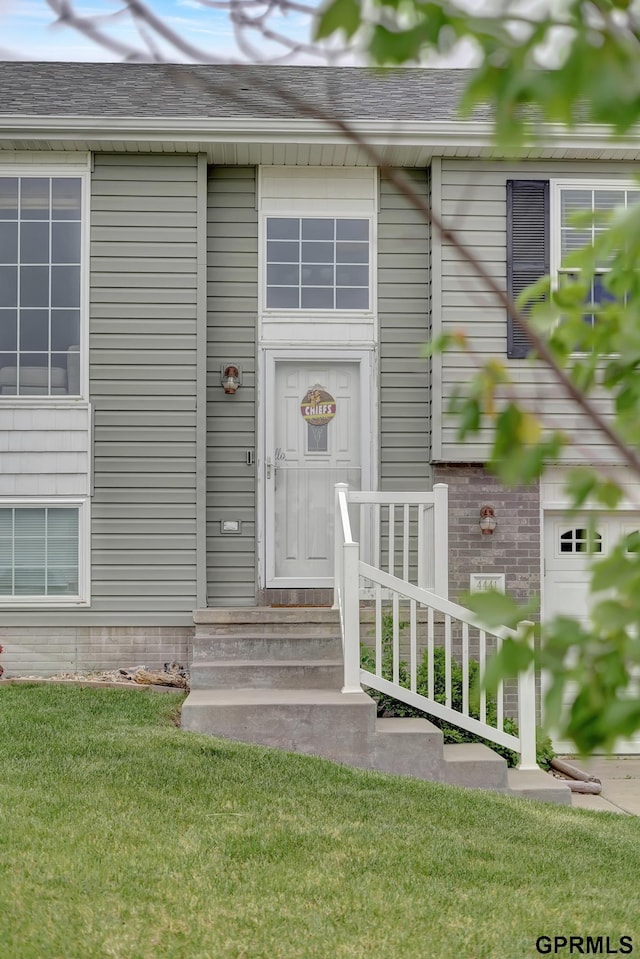 4441 W Hub Hall Dr, Lincoln, NE 68528 - view of exterior entry with a lawn and a shingled roof