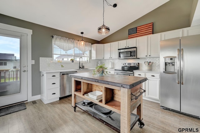 4441 W Hub Hall Dr, Lincoln, NE 68528 - kitchen featuring appliances with stainless steel finishes, a sink, lofted ceiling, white cabinets, and backsplash