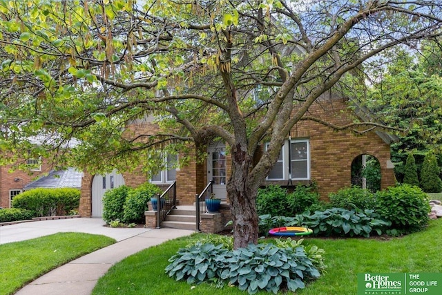 2028 N 55th St, Omaha, NE 68104 - obstructed view of property featuring brick siding, a front lawn, and concrete driveway