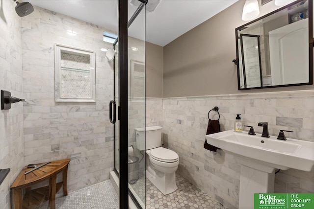 2028 N 55th St, Omaha, NE 68104 - bathroom featuring a shower stall, toilet, tile walls, tile patterned flooring, and wainscoting